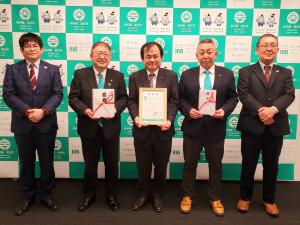 コープやまぐち様からの目録を市長が、コープかがわ様からいただいた寄付を市職員が、市からの感謝状をコープやまぐちの米原直樹専務理事がそれぞれ持ち、関係者5名が横一列に並んで撮影した写真