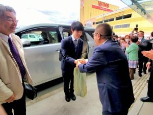 藤井聡太叡王がスーツを着た男性と両手で握手をしている写真