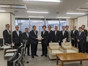 要望書を一緒に持つ男性2人と10名の関係者の男性達が横一列に並んでいる写真