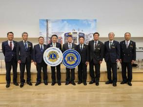ライオンズクラブ国際協会の方々が白と青を基調とした大きいエンブレムをそれぞれ持ち、市長とその他の市の職員の方々と並んで撮影した写真