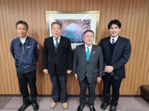 絵画が飾られた室内で、市長含め4名の関係者が横一列に並んでいる写真