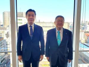 ガラス窓の前で坂尾耕作取締役社長執行役員と市長が並んで記念撮影をしている写真