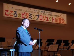 「こころのビタミンプロジェクトin宮古」と書かれた横断幕が飾られ、マイクの前で市長が挨拶をしている写真