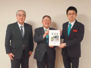 要望書を持った市長と男性、関係者の男性と3人で記念撮影をしている写真