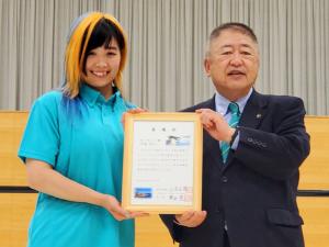 女子プロレス「マリーゴールド」のMIRAI選手と市長が一緒に任命書を持っている記念写真