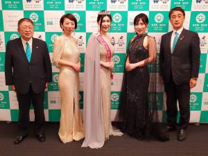 ティアラを付けドレスを着た坂本好子さんの他、ドレス姿の平内綾子さん、宮沢範江さんと、市長・副市長が並んでいる記念写真