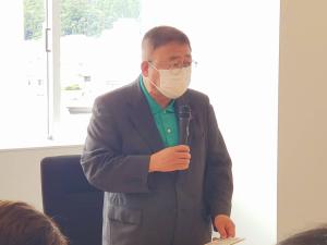 右手にマイクを持ちマスクをして話している様子の市長の写真
