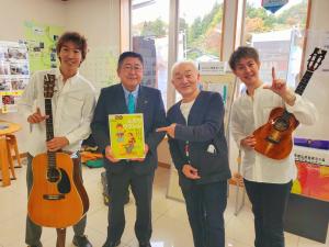 市長を中心にウクレレアーティストのキヨシ小林さんと、フラリーパッドの2人が横一列に並んでいる記念写真