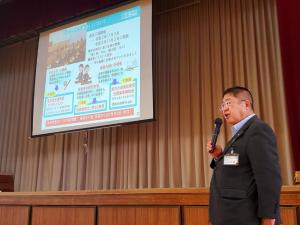 画面が映し出されたスクリーンの横でマイクを持ち話をしている市長の写真