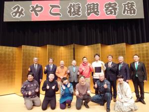 みやこ復興寄席と書かれた横断幕の下の金屏風の前で、出演された皆さんと市長の集合写真