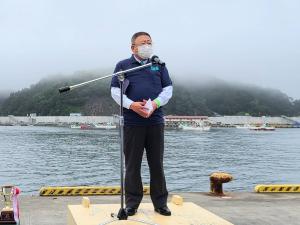 宮古港カッターレースの開会式に出席した市長が、マイクスタンドの前で挨拶を行っている様子の写真