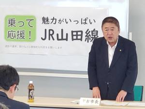 「魅力がいっぱいJR山田線」と書かれた用紙が貼ってあるホワイトボードの前で、市長が自席で立って話をしている写真