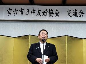 「宮古市日中友好協会交流会」と書かれた横断幕の下の金屛風の前で、市長が話をしている写真