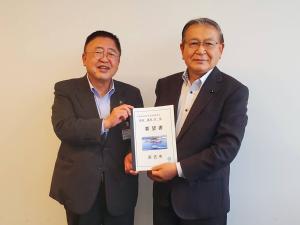 市長と男性が要望書の冊子を両手で一緒に持ち写っている写真