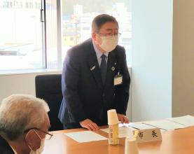 「市長」と書かれた名札の前に市長が立ち、経営戦略について述べている写真
