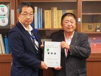 本棚の前で市長と男性で要望書を持っている写真