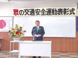 「秋の交通安全運動表彰式」と書かれた横断幕の前で、市長が式辞用紙を開いて話をしている写真