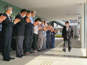 整列した職員たちが拍手をし、職員たちの前を歩く様子の市長の写真