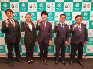 宮古市のバックパネルの前で、2名の男性と1名の女性、両端に市長と副市長がガッツポーズをして横一列に並んでいる地域おこし協力隊辞令交付式の様子の写真