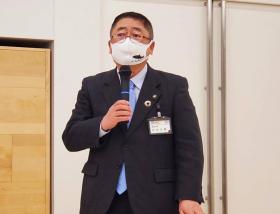 研修会でマスク姿の市長が立って片手にマイクをもちながらあいさつを述べている写真