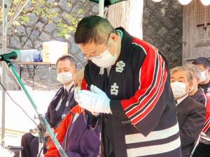 白い手袋を着け法被を着た市長が、目をつぶり頭を少し下げ合掌している様子の写真