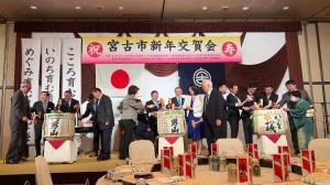 宮古市新年交賀会の舞台の上に3ケの酒樽が用意され関係者の方が囲んでいる写真
