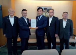 要望書を一緒に持つ男性2人、その両側に並ぶ市長と男性2名が写った写真