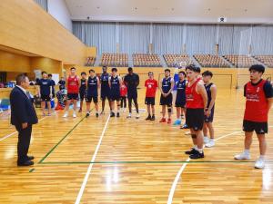 体育館で赤や青のビブスを着た岩手ビッグブルズの選手の前で、市長が話をしている写真