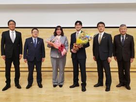花束をもった山本千香さんと松下竜之介さんの両脇に、市長、他の市職員が2名ずつ並んで撮影した写真
