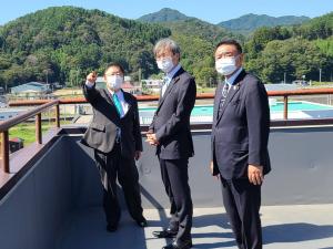 建物の屋上で遠くを指さす市長と秋葉賢也復興大臣、中野英幸復興大臣政務官を写した写真