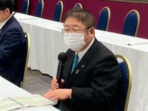市長が自席で座り、資料を見ながらマイクで話している写真