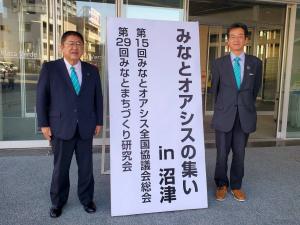 みなとオアシスの集いin沼津の立て看板の両サイドに市長と男性が立っている写真