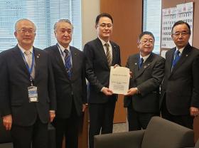 議員室で市長が木戸口英司参議院議員に港湾の整備・振興の要望書を渡しているところに同行した他の岩手県内の市長も並んで5人で撮影した写真