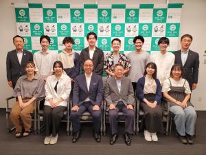 バックパネルの前で、前列は4名のゼミ生の間に市長と東秀和教授が並んで座り、後方に副市長と男性の間に6名のゼミ生が並んで立って撮影した写真