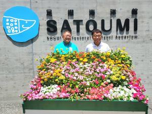 足摺海洋館SATOUMI入口の花壇の奥に立つ市長と男性の写真