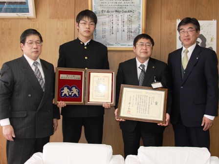 受賞した賞状と盾を両手に持った宮古工業高校の生徒と、額縁に入った賞状を両手に持つ市長と関係者が並んでいる写真