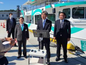 港に停泊する宮古うみねこ丸の前で、話をする秋葉賢也復興大臣とその両側に立ち話を聞く市長と中野英幸復興大臣政務官の写真