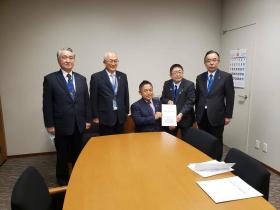 議員室で市長が横沢高徳参議院議員に港湾の整備・振興の要望書を渡しているところに同行した他の岩手県内の市長も並んで5人で撮影した写真