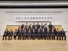 令和2年度退職者辞令交付式と書かれた幕の下で、退職される方々と市長が集合して撮影した写真