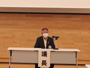 長机の中央に議長と書かれた紙が貼られた席に着席した市長が、マイクの前で話をしている会議の様子の写真