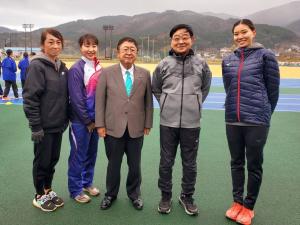 陸上競技場で市長を中央に、大村邦英先生と3名の女性講師が横一列に並んでいる写真