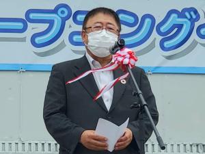 紅白テープが巻かれたスタンドマイクの前で話をする様子の市長の写真