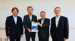 ホワイトボードの前で、中央に小岩利弘釜石港湾事務所長と市長が要望書を一緒に持ち、2名の関係者と横一列に並んでいる写真