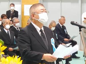 宮古市戦没者追悼式の会場に設置されたマイクスタンドの前で挨拶を行っている黒色のスーツを着用した市長をアップで撮影した写真