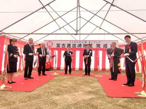 「宮古港出崎地区完成式」と書かれた横断幕が掲げられ、側面に紅白幕が掛けられたレッドカーペットが敷かれたテントの下で、市長や6名の関係者が並びテープカットが行われている様子の写真