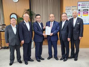 中央に要望書を一緒に持つ男性2人、両端に市長を含めた男性4人が並んでいる写真