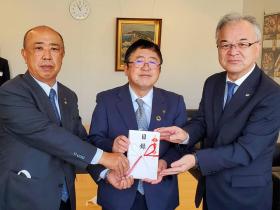 市長を真ん中にして、東北電力ネットワーク株式会社の方、株式会社ユアテックの方で寄贈の目録を持っている写真