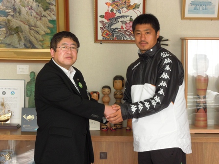 市長と小笠原満男選手が両手で握手をし記念撮影している写真