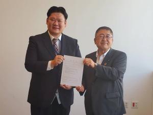 任命書を一緒に持つ男性と市長の記念写真