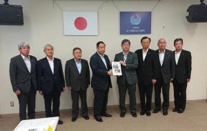 市長や東北地方整備局の関係者らスーツ姿の男性9名が横一列に並び中央に立つ2名が2人で要望書を持っている写真